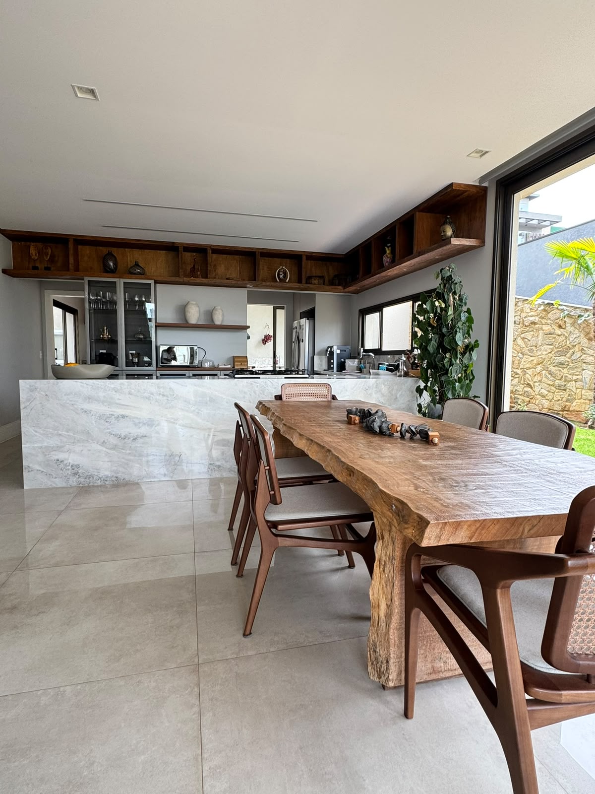 Sala de jantar com mesa e cadeiras de madeira integrada à cozinha